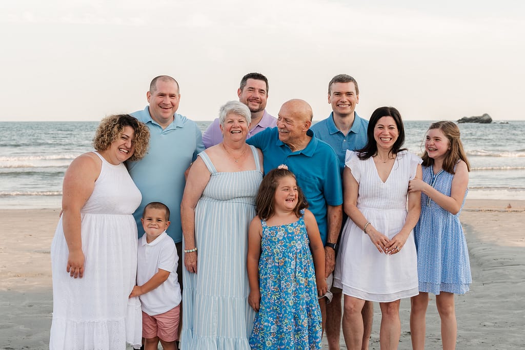 extended family poses for family photos on beach in newport