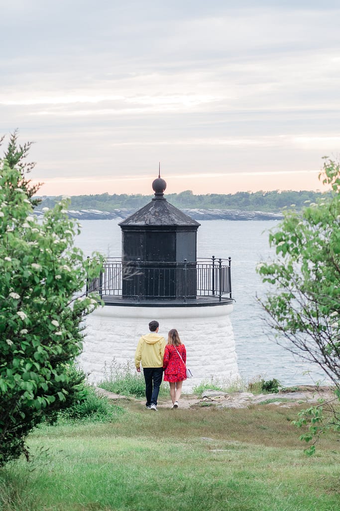 couple walks toward lighthouse