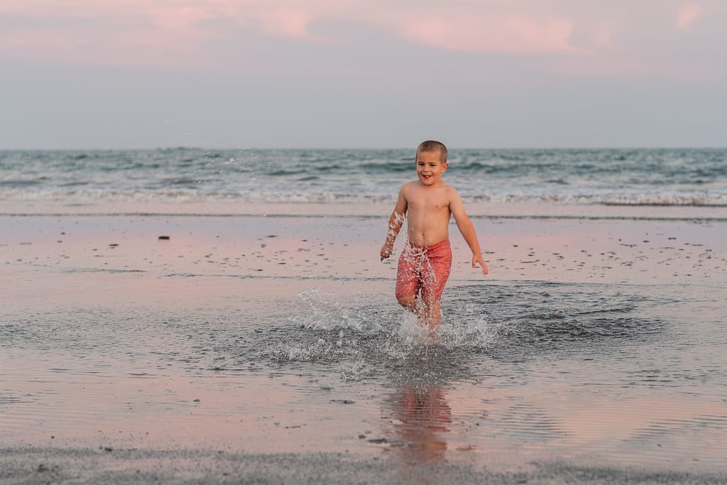 boy splashes on beach in newport