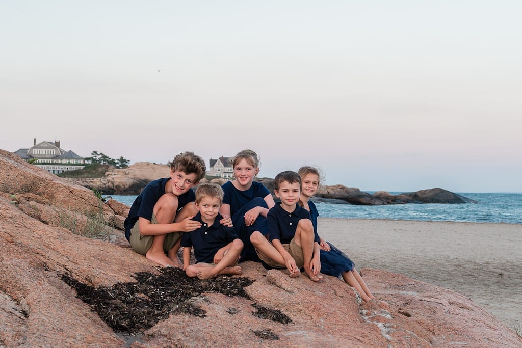 kids pose for portraits on a rock