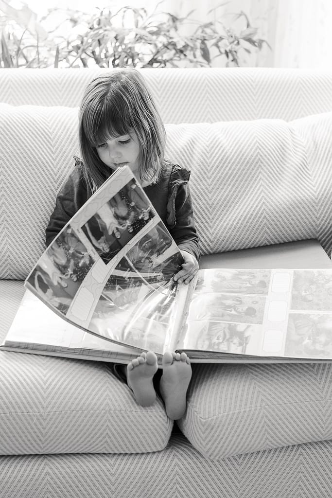girl reads heirloom photo album