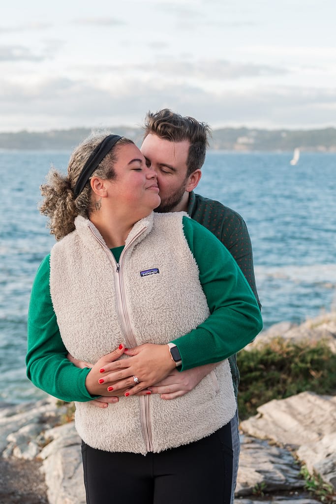 couple snuggles after newport proposal