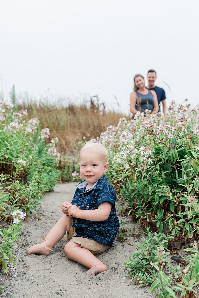 toddler sits in front of parents for newport family photos