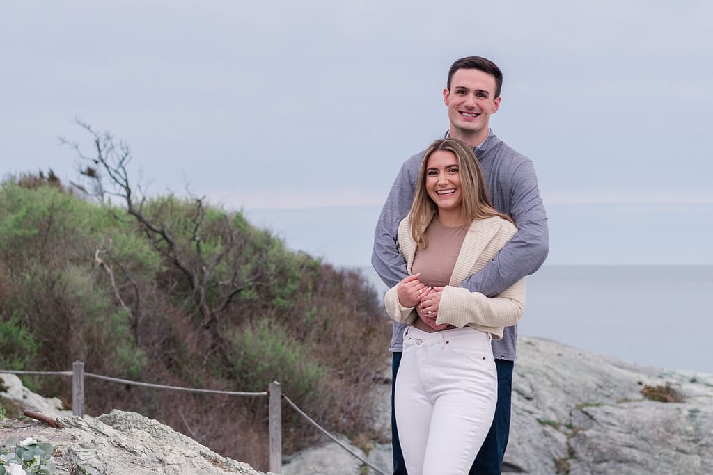 couple poses at castle hill after engagement