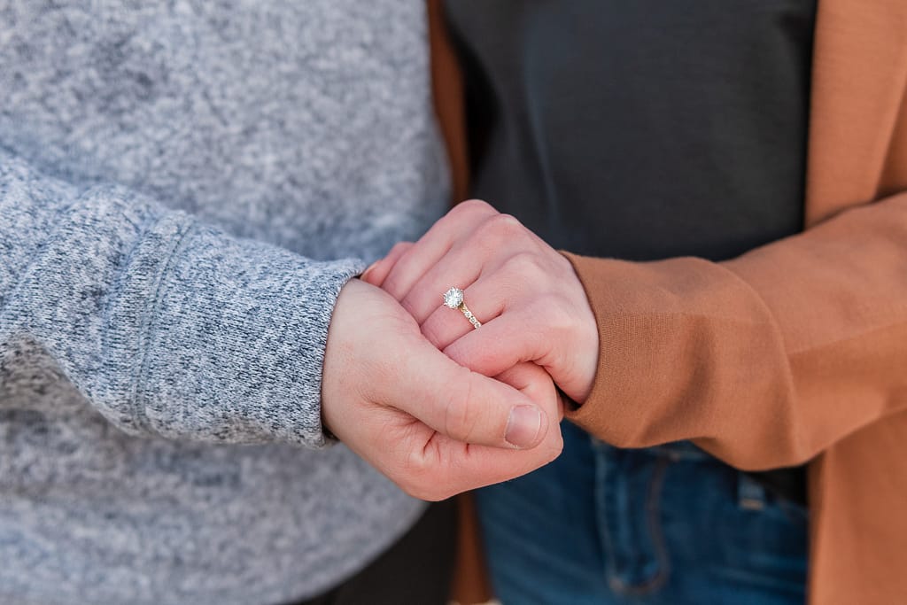 couple holds hands after newport surprise engagement