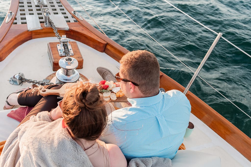 couple enjoyes charcuterie board on sunset cruise in newport