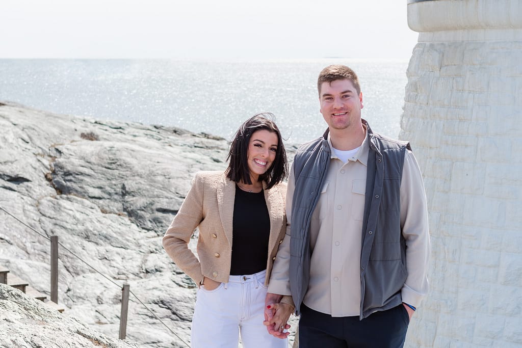 couple stands near castle hill lighthouse after engagement