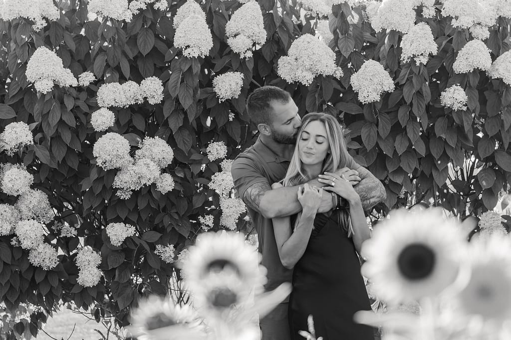 couple hugs in field of flowers