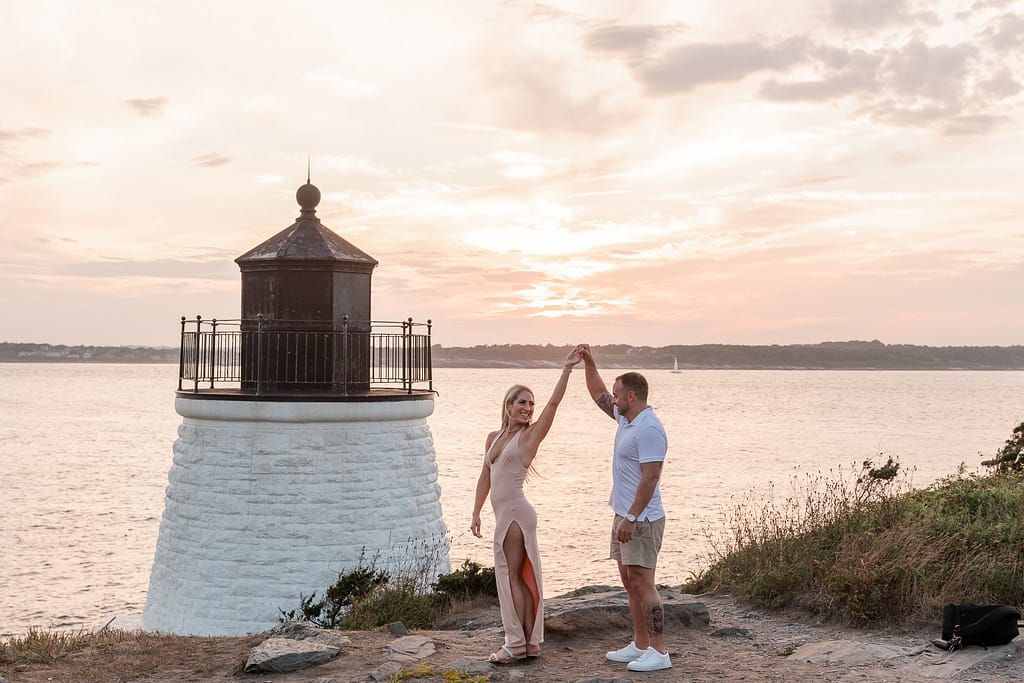 couple dances in front of castle hill lighthouse after proposal