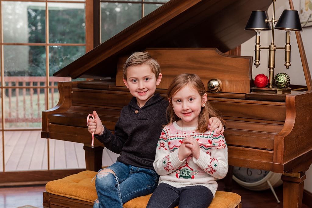 kids sit near piano with candy canes