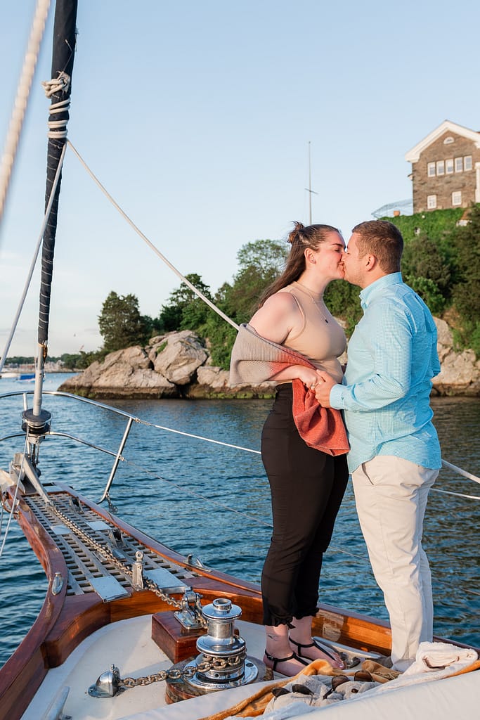 couple kisses after proposal on a boat