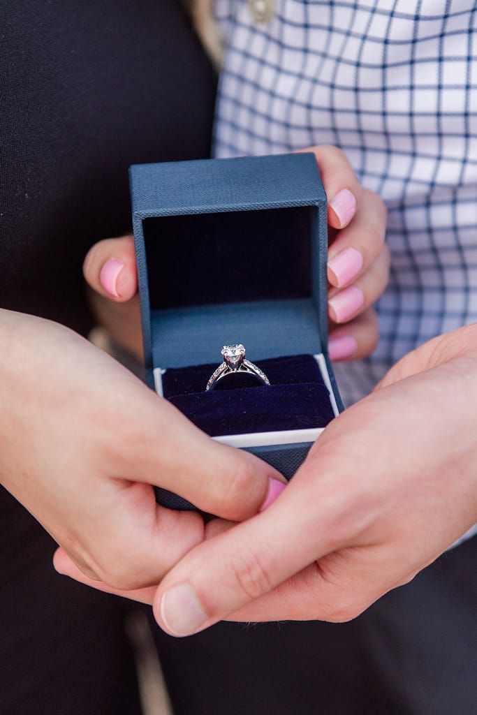 couple holds engagement ring