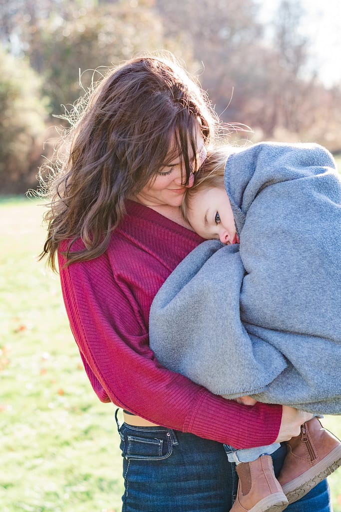 mother holds son during fall family photos