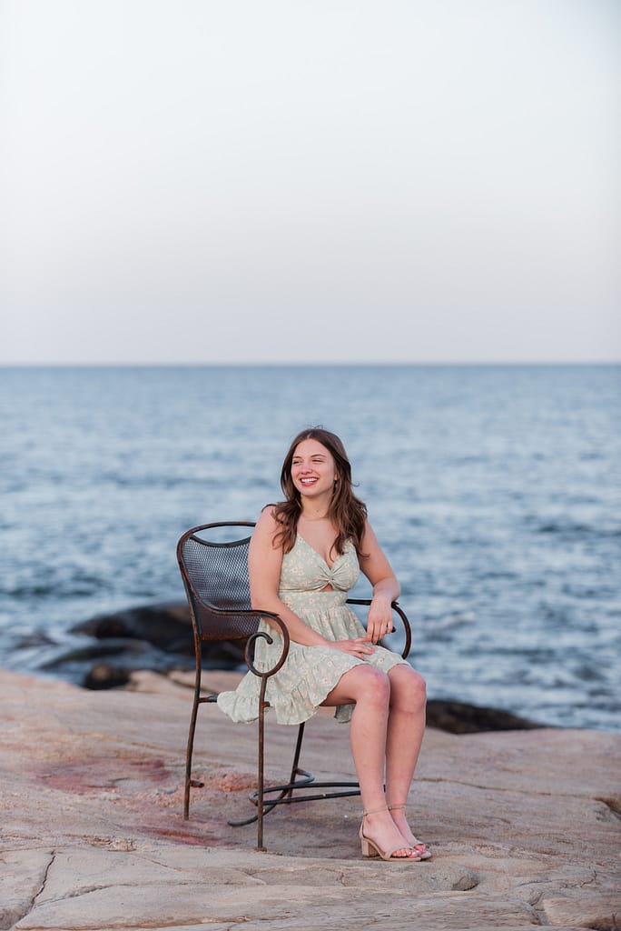 girl sits in chair for senior portraits