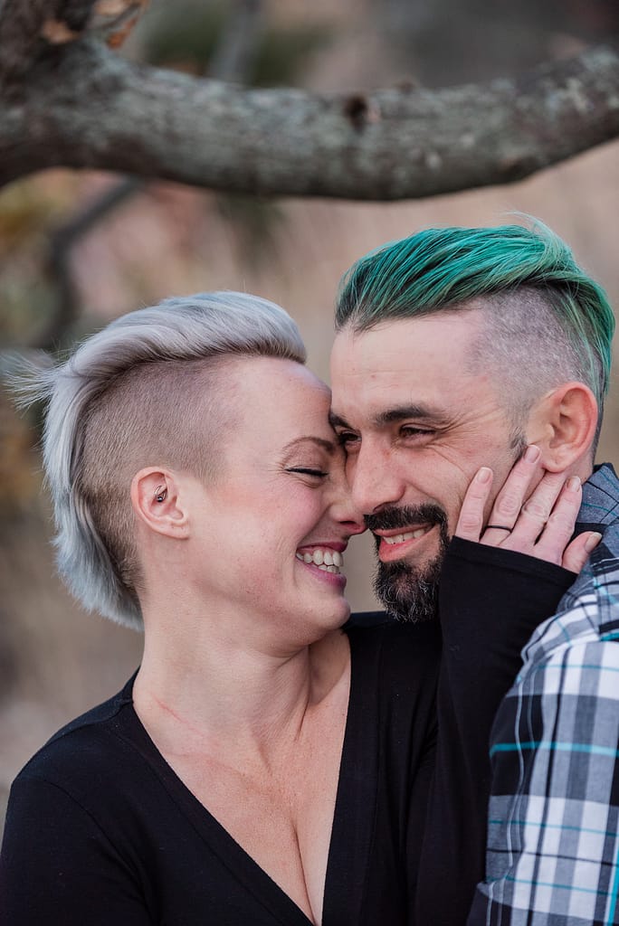 couple nuzzles and smiles for engagement portraits