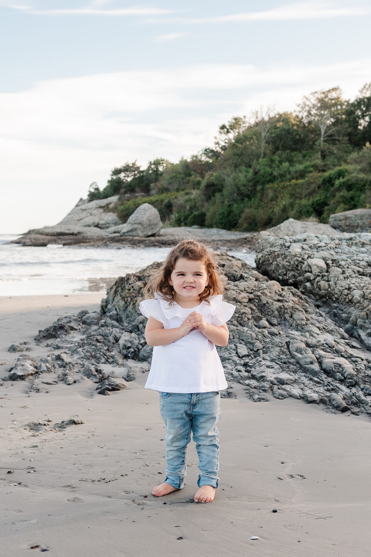 toddler girl smiles on beach
